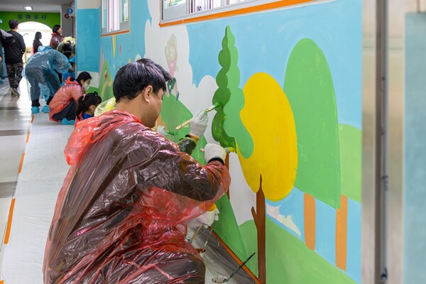 '가족과 함께하는 벽화 그리기' 봉사활동에 참여하고 있는 한국앤컴퍼니그룹 임직원들. 사진=한국앤컴퍼니그룹
