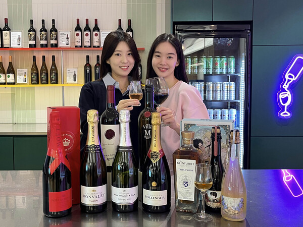 GS25에서 모델이 2025 와와페 주류 상품을 선보이고 있다. 사진=GS리테일 제공