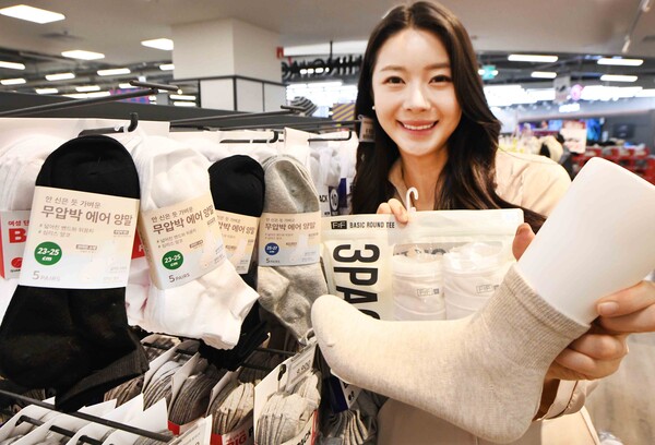모델이 ‘홈플러스 메가 푸드 마켓 라이브’ 강서점에서 ‘무압박 에어 양말’과 ‘F2F 베이직 반팔티’ 상품을 소개하고 있다. 사진=홈플러스 제공
