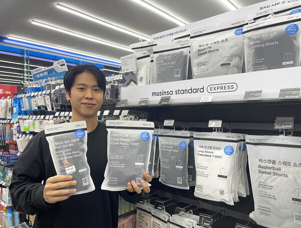 고객이 동절기를 맞아 GS25에서 새롭게 선보이는 무신사 스탠다드 상품들을 들고 포즈를 취하고 있다. 사진=GS리테일 제공