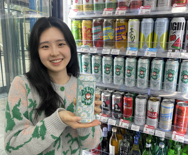 고객이 GS25에서 피스마이너스원의 디자인과 지드래곤 상징을 담은 ‘데이지에일’ 맥주를 들고 포즈를 취하고 있다. 사진=GS리테일 제공