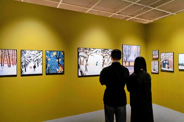 잠실점 아트홀에서 진행하는 겨울, 그 따뜻한 순간들 전시를 관람하고 있는 고객들의 모습. 사진=롯데백화점 제공